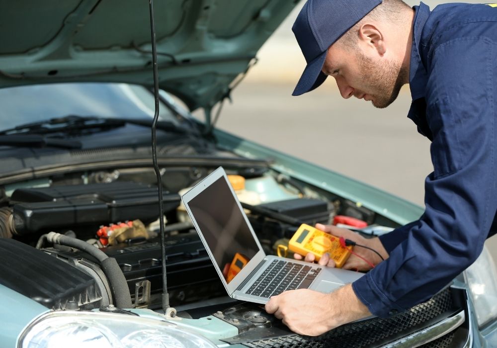 KFZ-Gutachter überprüft den Motor mit einem Diagnosegerät