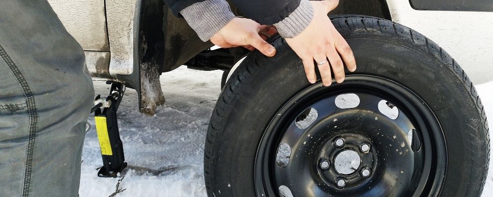 Reifenwechsel auf verschneiter Straße – Wintercheck Auto