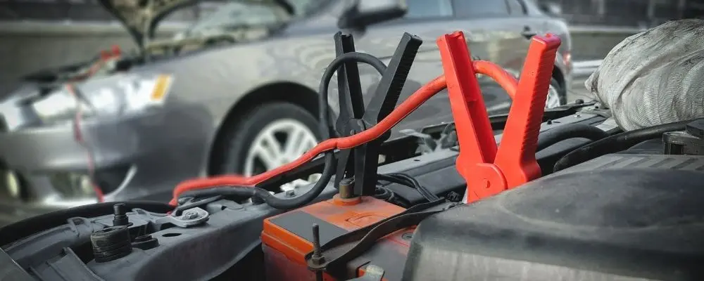 Autobatterie mit Starthilfekabeln bei Batterieproblemen im Sommer