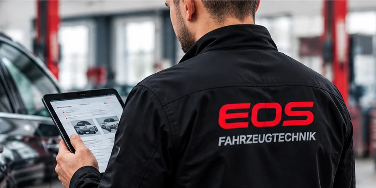 KFZ-Gutachter von EOS Fahrzeugtechnik prüft ein Fahrzeug mit dem Tablet