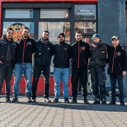 Gruppenfoto der Filialmitarbeiter von EOS Fahrzeugtechnik vor dem Ladengeschäft.